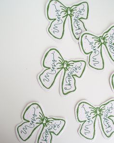 four green and white stickers with bows on them