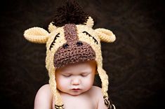 a baby wearing a crocheted hat with a giraffe design on it