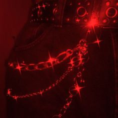 a pair of chains attached to the back of a woman's pants with red lights shining on them