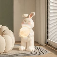 a white rabbit lamp sitting on top of a rug