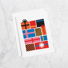 a greeting card with colorful gift wrappings on it, sitting on a marble surface