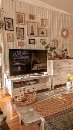 a living room filled with furniture and pictures on the wall behind a flat screen tv