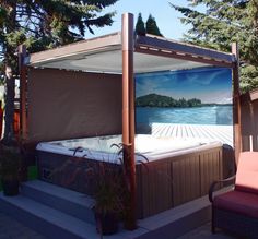 an outdoor hot tub in the middle of a deck with a painting on it's side