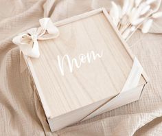 a wooden box with the word mom written on it and a bow tied around the lid