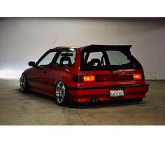 a red car parked in a garage next to a white wall