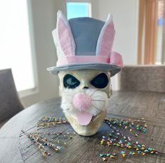 a cat mask on top of a wooden table with sprinkles around it