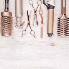 several different types of hairbrushes and combs on a white wooden background with space for text