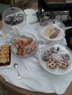 a table topped with lots of different types of pastries and desserts on plates