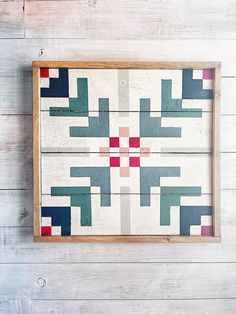 a wooden frame with an abstract design on the inside and outside, hanging on a white painted wood wall