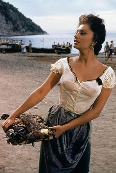 a woman holding a bird on the beach