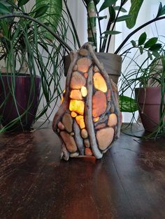 a potted plant sitting on top of a wooden table next to a stone lamp