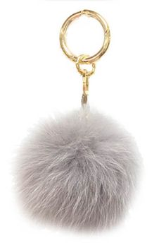 a keychain with a fur ball hanging from it's center, on a white background