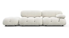 a white couch with two pillows on it's back and one arm facing the camera