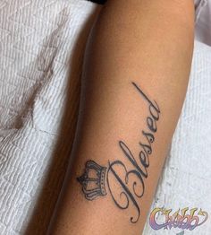 a person with a tattoo on their arm that says, dearly and crown in cursive writing