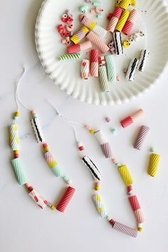 paper beads are arranged on a plate next to a string