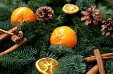 an arrangement of oranges, cinnamon sticks and pine cones