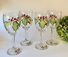 three wine glasses decorated with holly and berries