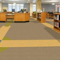 an empty library with bookshelves and desks in the middle is seen from across the room