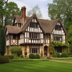 an old style house in the middle of some trees and grass with bushes around it