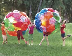 four children playing with giant inflatable balls