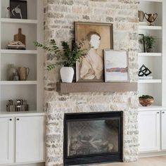 a living room filled with furniture and a fire place in front of a brick wall