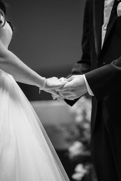 a bride and groom holding hands during their wedding ceremony