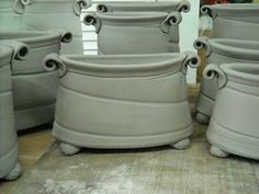 several cement pots sitting on top of a wooden table