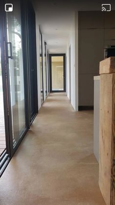 an empty hallway with glass doors leading to the outside