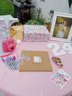 a pink table topped with lots of crafting supplies