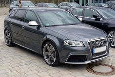 a grey car parked in front of other cars