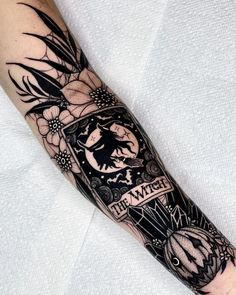 a man's arm with a tattoo on it that says the witch and flowers