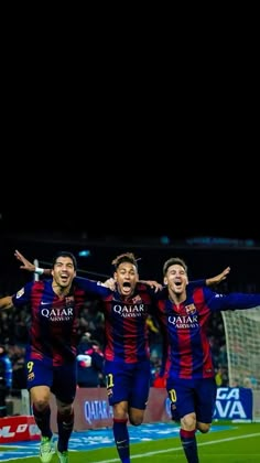 three soccer players are celebrating on the field