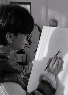 a woman is drawing on a piece of paper