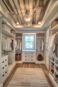 a walk in closet with white cabinets and drawers