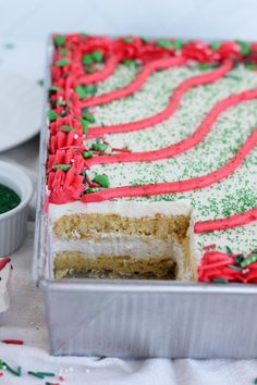 a cake with red and green frosting in a tin on top of a table