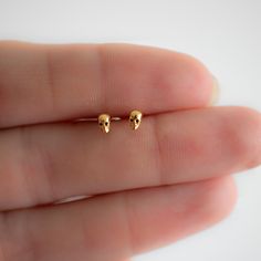 Our tiny gold skull studs are an edgy addition to your collection. Designed for everyday wear our tiny skull studs look great on their own and are perfect for stacking. Our tiny skull gold studs come packaged in our branded gift box, ready for gifting. * ＤＥＴＡＩＬＳ: - 14 K Gold vermeil (sterling silver base) - Perfect for sensitive ears - Ships next business day - Made in Oakville, ON. * C A R E: - remove when swimming, showering or exercise - gently clean with warm water and baking soda - use a to Edgy Gold Cartilage Earrings, Punk Jewellery, Jewellery Minimalist, Types Of Ear Piercings, Earrings Punk, Bookish Stuff, Earrings Gothic, Minimalist Earring, Evil Eye Necklace Gold