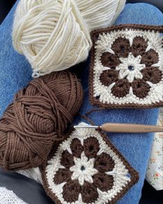 crocheted grannys and balls of yarn sitting on top of a blue blanket