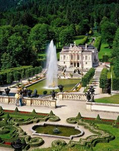 an aerial view of a large building with a fountain in the middle