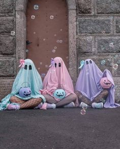 three ghost dolls sitting on the ground in front of a door with bubbles floating around them