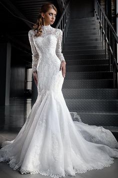 a woman in a wedding dress standing next to stairs