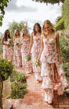 bridesmaids in floral dresses walking down the path