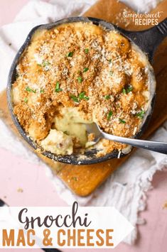 a pan filled with macaroni and cheese on top of a wooden cutting board