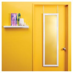 a bathroom with yellow walls and a white mirror on the wall next to a shelf