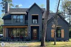 a large gray house with lots of windows and wood trimmings on the front