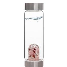 a glass water bottle filled with ice and some pink rocks in the water on a white background