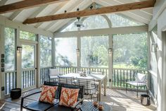 an enclosed porch with chairs and tables on it