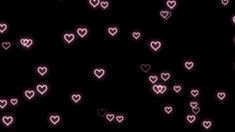 many pink hearts are glowing in the dark