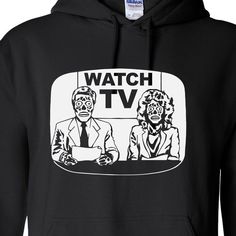 a black hoodie with the words watch tv on it and two people sitting at a table