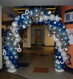 an arch made out of balloons with musical notes and stars on the front, along with other decorations