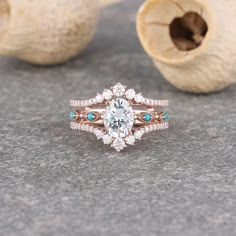 an oval cut diamond ring with blue and white stones in the center, surrounded by shells